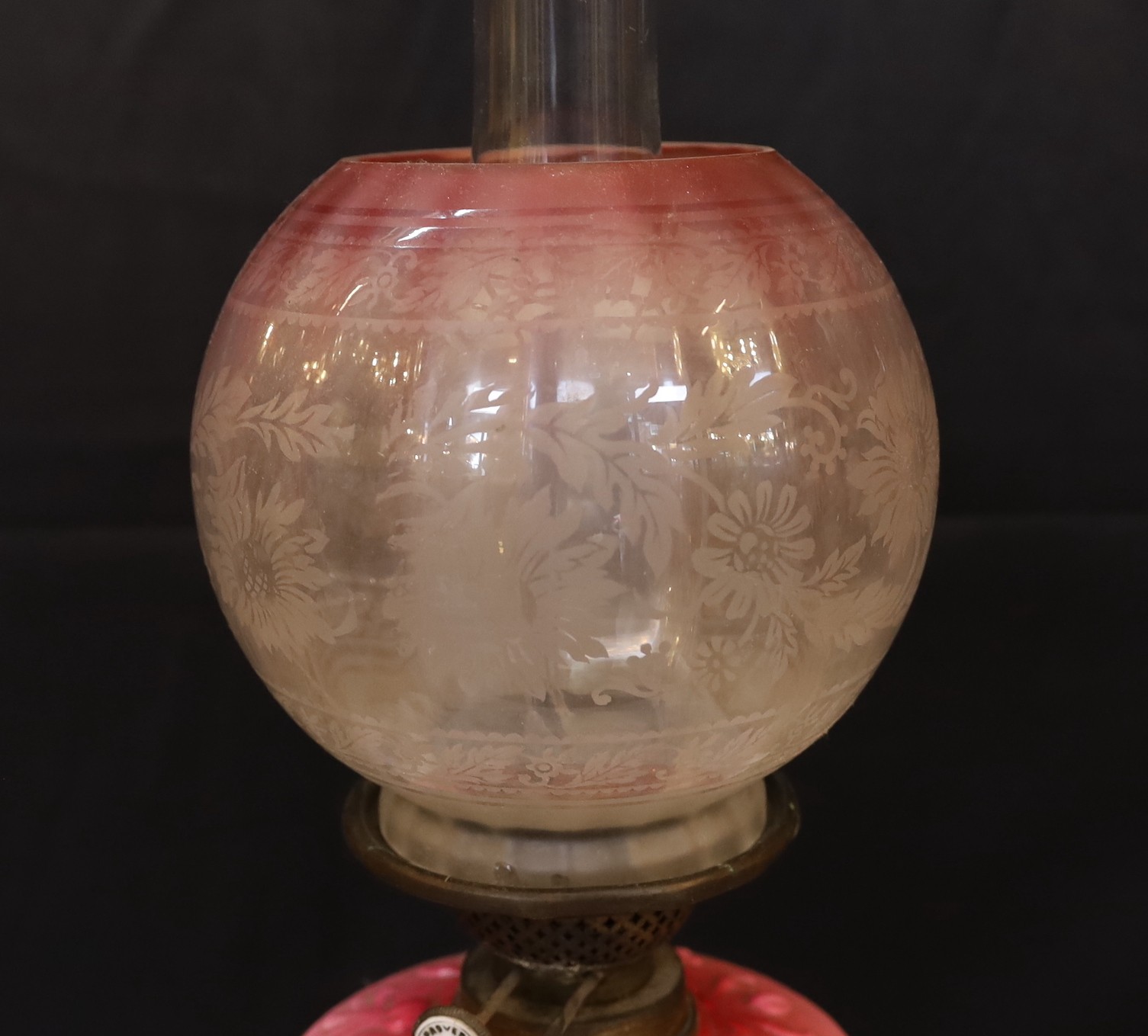 A late Victorian brass and opaque pink glass oil lamp, with Burnes duplex mechanism, pink tinted etched glass globe and flue, height overall 71cm